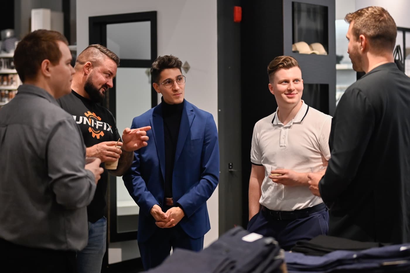 Des entrepreneurs discutent un verre à la main dans la boutique M2